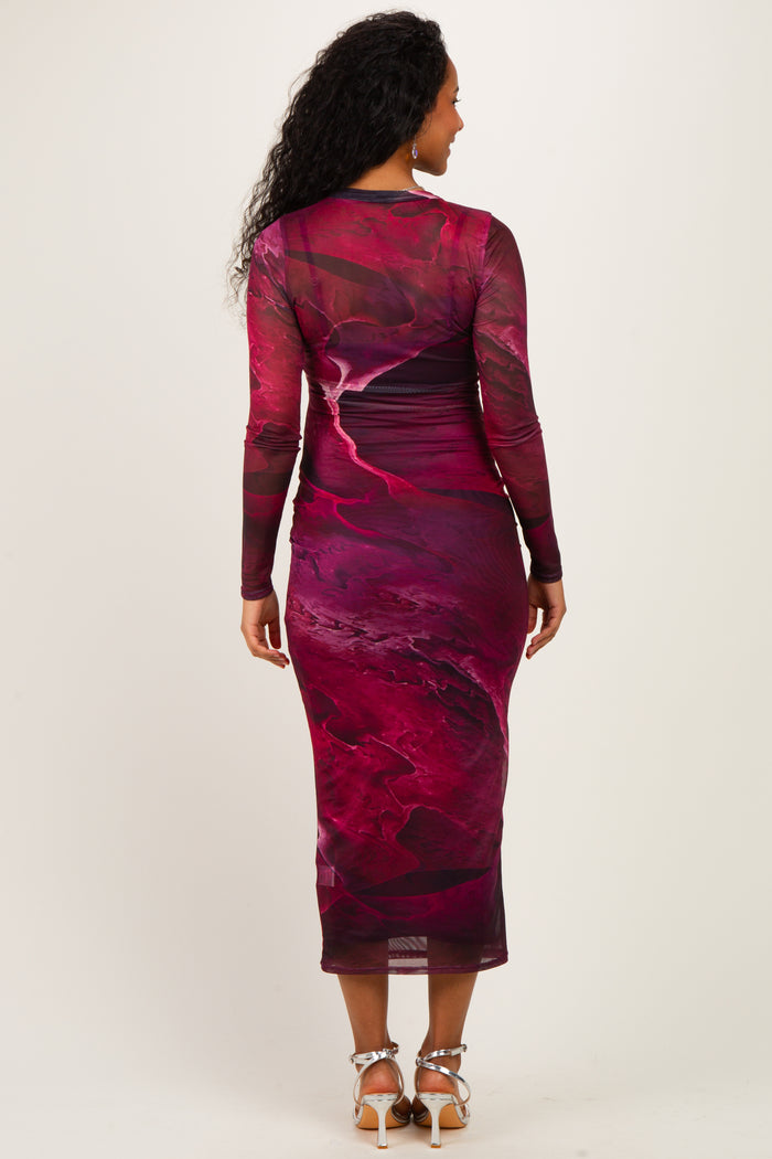 woman wearing a form-fitting maroon printed maternity dress with long sleeves, showing a flowing design from the back
