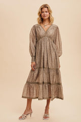 woman wearing a taupe floral maxi dress with puff sleeves and tiered skirt