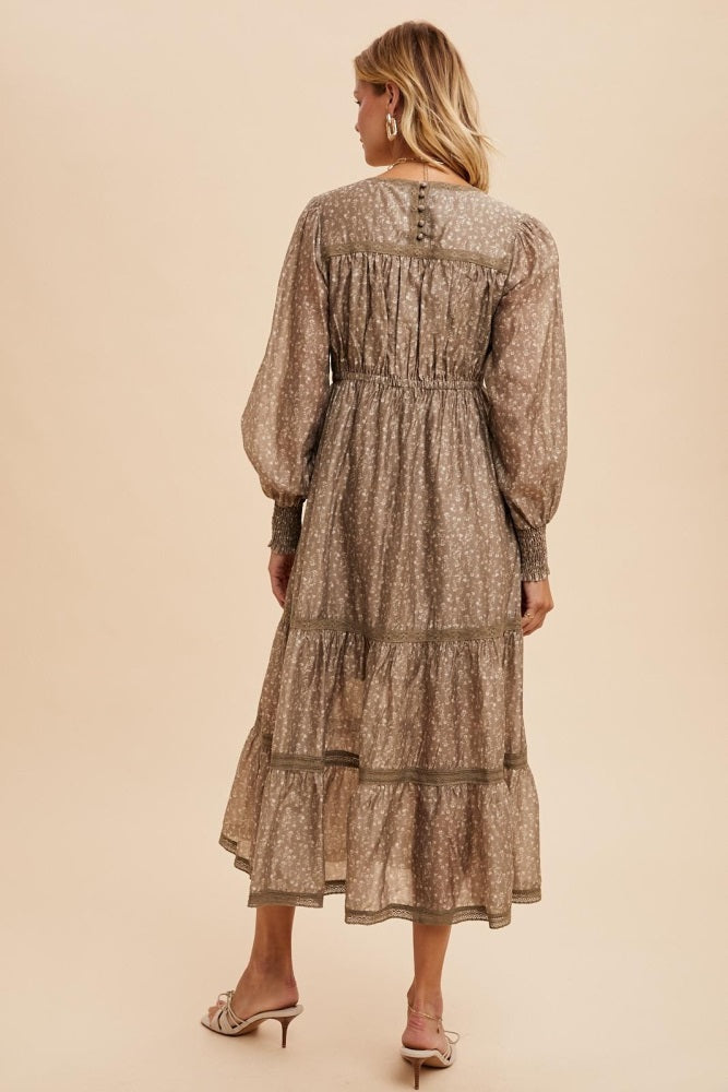 woman wearing a brown floral long sleeve maxi dress with tiered skirt and gathered waist detail