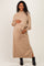 woman wearing a tan maternity sweater dress with a tie waist and long sleeves, showing her baby bump