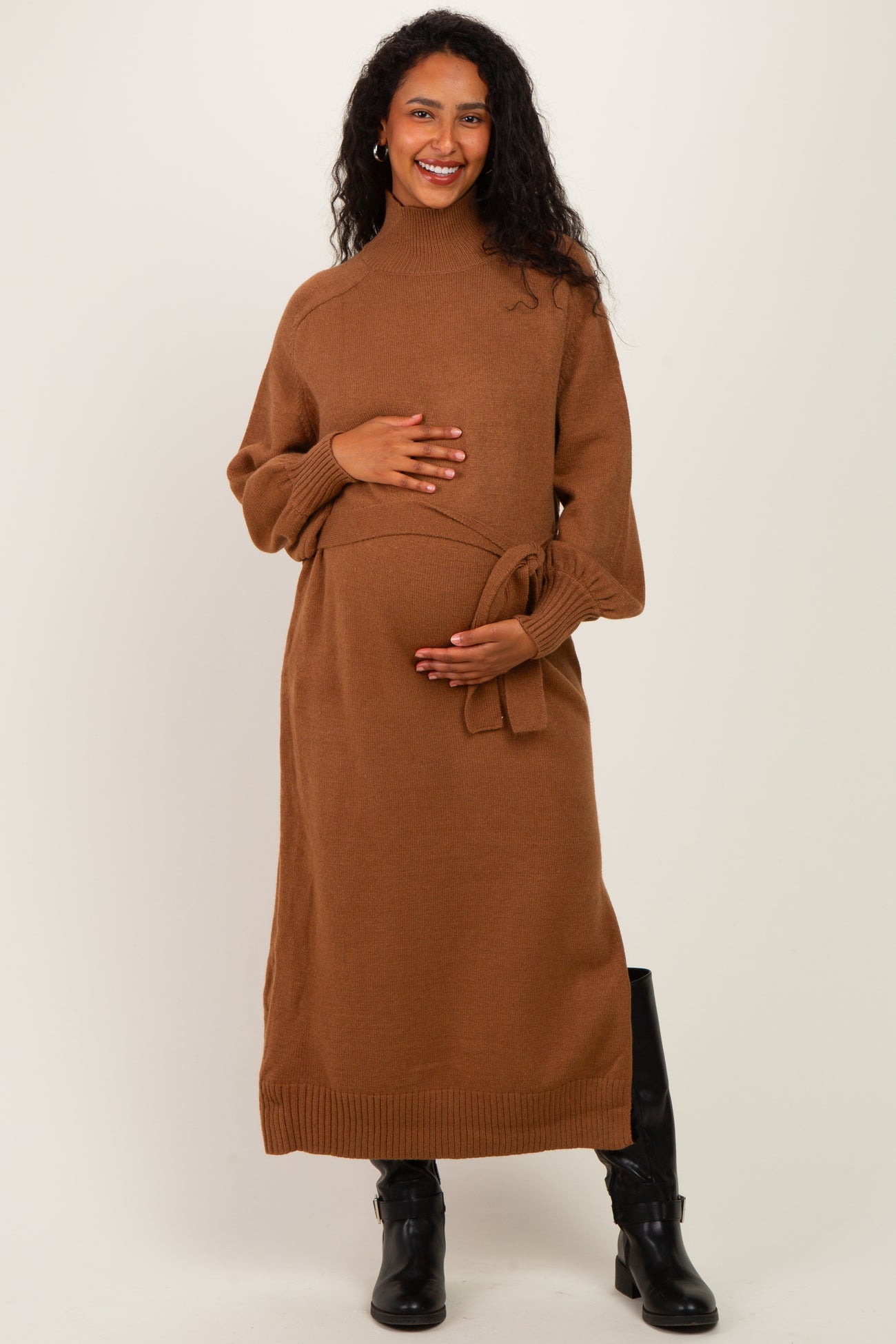 woman wearing a brown maternity sweater dress with a tie waist and a visible baby bump