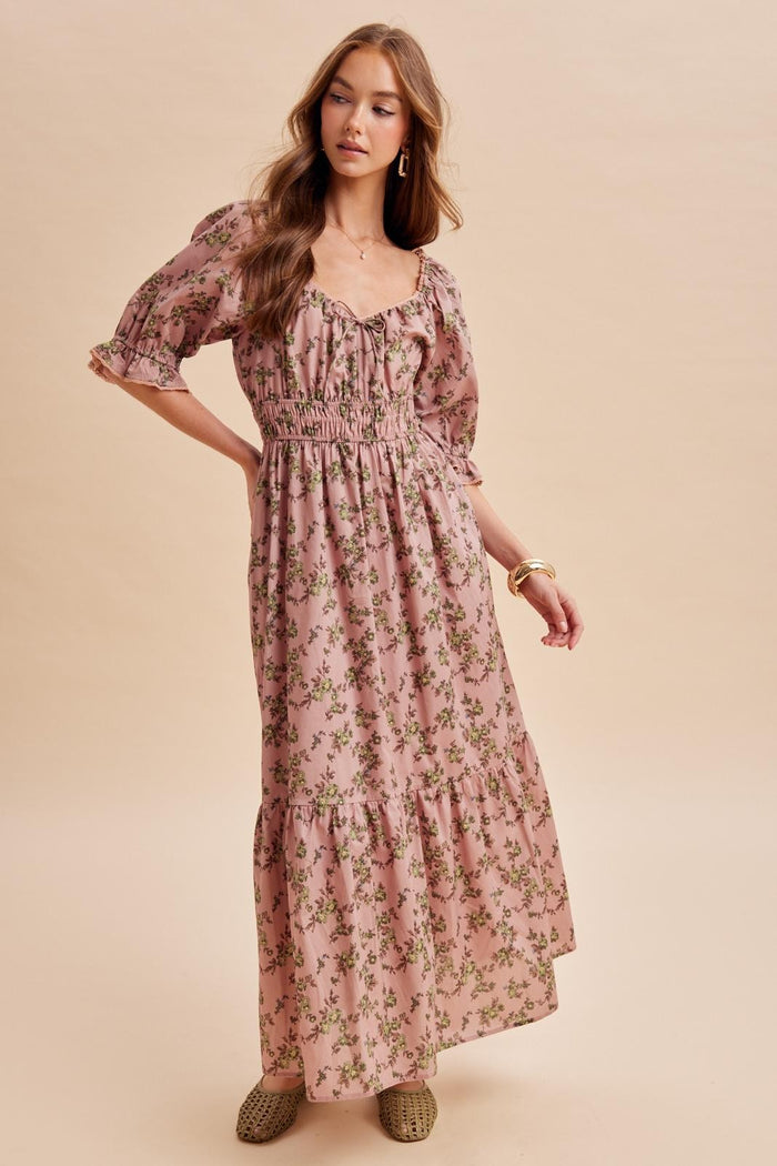 woman wearing a pink floral maxi dress with puff sleeves and a smocked bodice