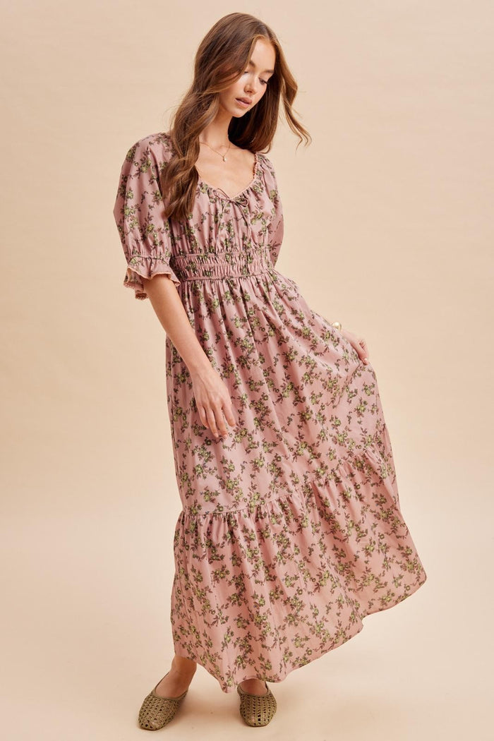 woman wearing a pink floral maxi dress with smocked waist and ruffled sleeves