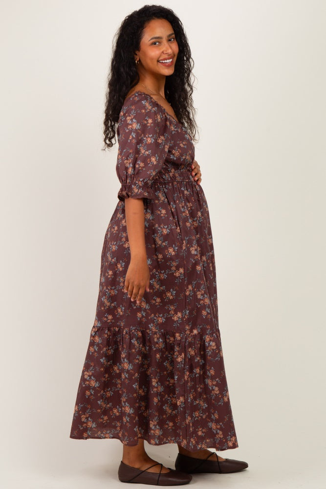 woman wearing a brown floral maternity maxi dress with puff sleeves and a baby bump visible