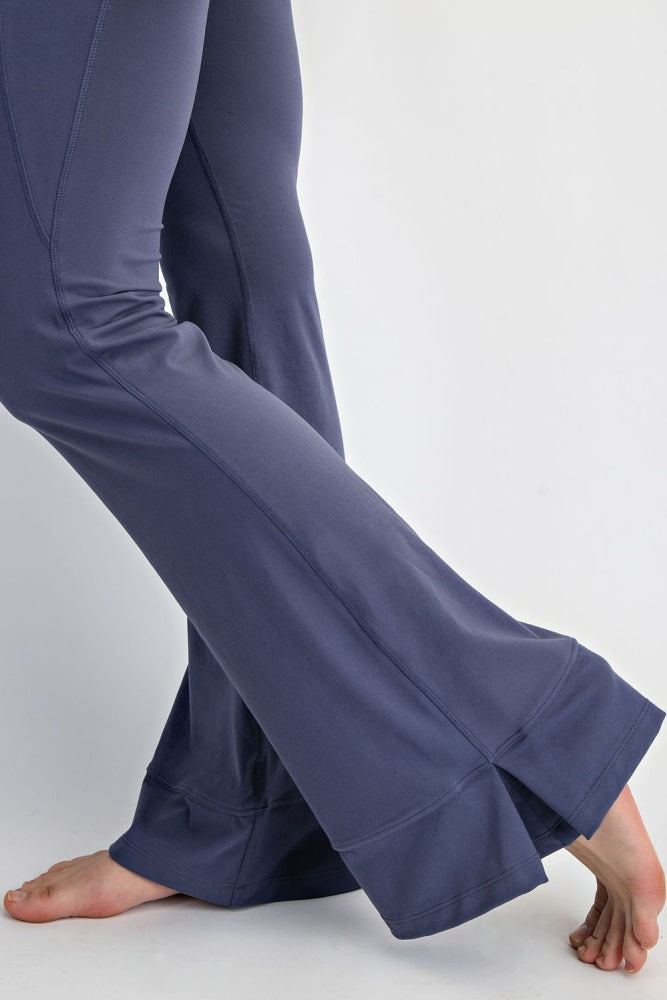 navy blue flared yoga pants with side slits, showcased on a bare-footed model
