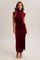 woman wearing a burgundy velvet sleeveless midi dress with side ruching and a high neckline