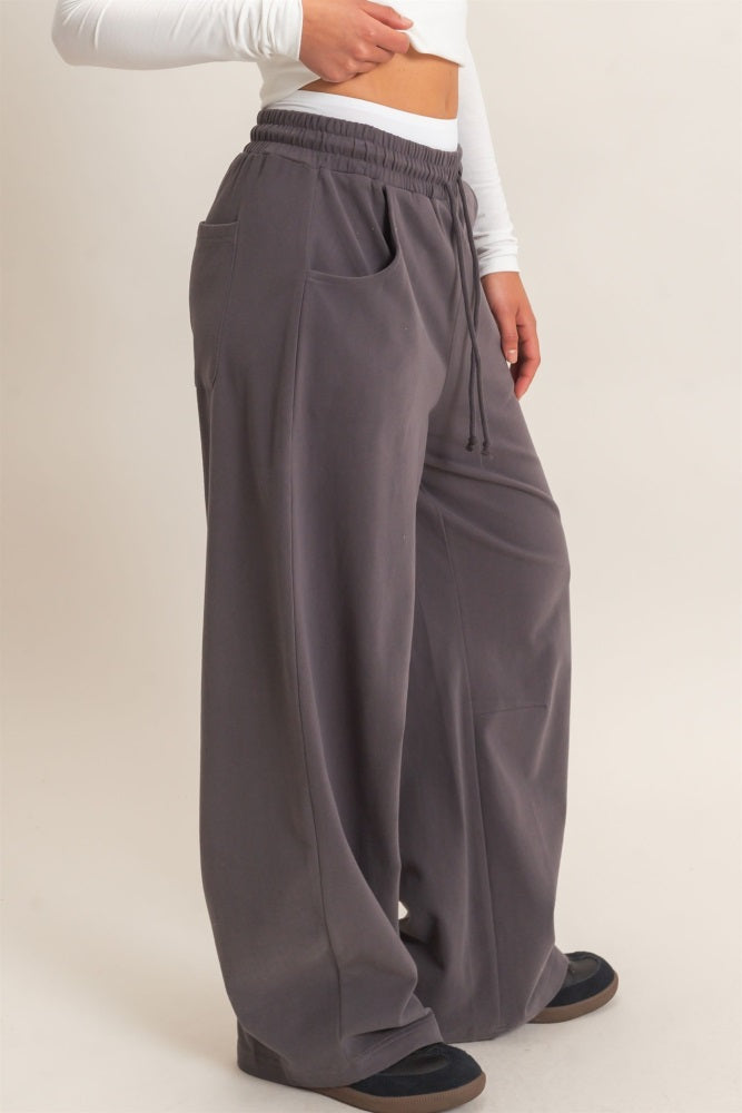 woman wearing loose-fit gray wide-leg pants with an elastic waistband and side pockets