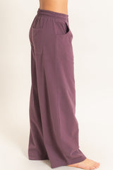 woman wearing high-waisted wide leg purple pants with side pockets and an elastic waistband