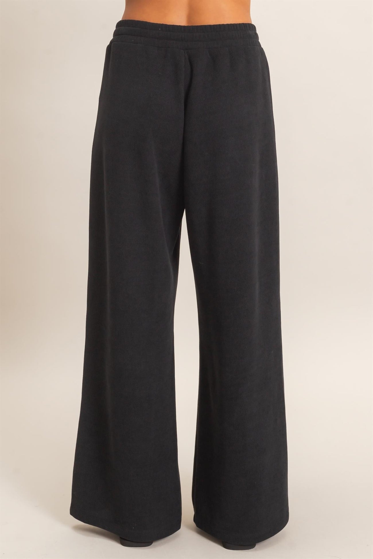 woman wearing black wide leg lounge pants with a ribbed texture
