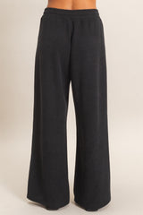 woman wearing black wide leg lounge pants with a ribbed texture