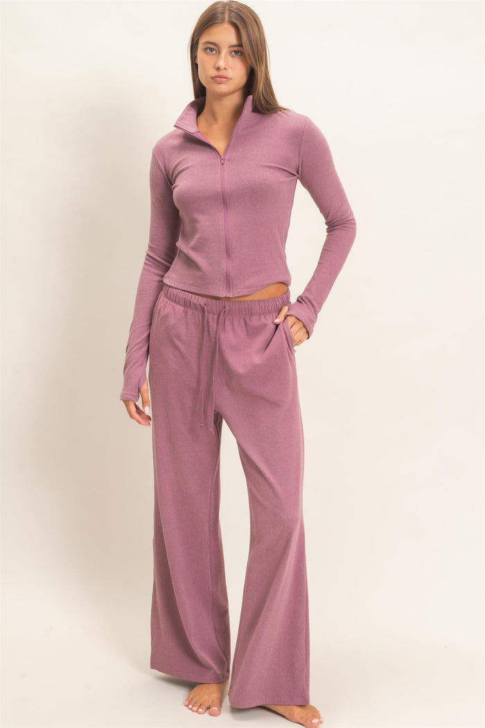 woman wearing a dusty rose zip-up long sleeve top and matching wide-leg lounge pants