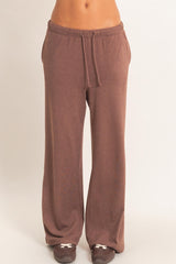 woman wearing brown wide-leg lounge pants with an elastic waistband and drawstring detail