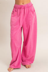 woman wearing loose-fitting hot pink wide-leg pants with side pockets and an adjustable drawstring waistband