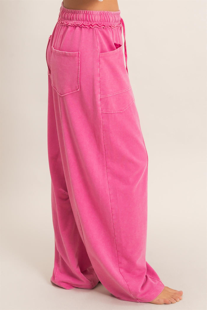 light pink wide-leg pants with an elastic waistband and side pockets, styled for women
