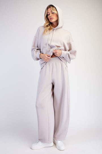 woman wearing a light taupe oversized hoodie and matching wide-leg sweatpants with a relaxed fit