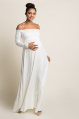 woman wearing a white off-shoulder maternity dress and holding her baby bump