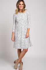 woman wearing a white and black striped long sleeve babydoll dress with tan peep toe booties