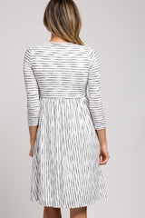 woman wearing a white and black striped three-quarter sleeve dress with a flared skirt from the back