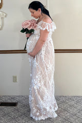 pregnant woman in white floral lace maternity dress holding a bouquet of pink roses