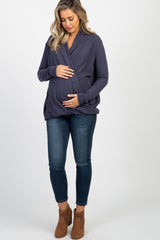 woman wearing a purple long sleeve draped front top and distressed blue skinny jeans