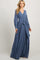 woman wearing a long sleeve blue maternity maxi dress with a wrap front and waist tie