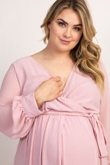 woman wearing a light pink long sleeve wrap maternity dress with a v-neckline