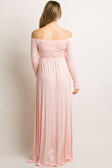 woman wearing a light pink off-shoulder maternity maxi dress, viewed from the back
