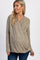 woman wearing a light brown wrap maternity top with long sleeves and a visible baby bump