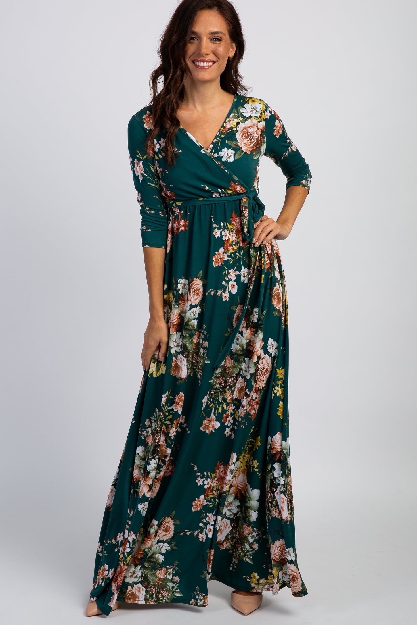 woman wearing a teal floral maxi dress with long sleeves and a wrap design
