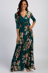 woman wearing a teal floral maxi dress with long sleeves and a wrap design