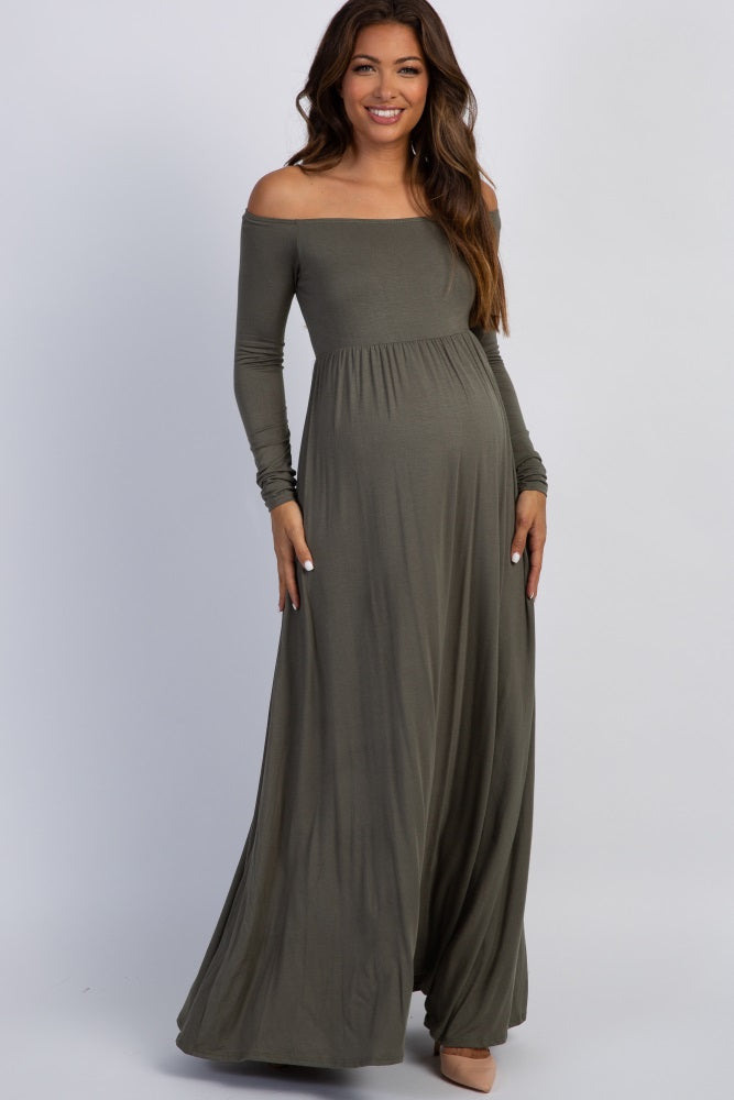 woman wearing a long sleeve olive green maternity dress and holding her baby bump