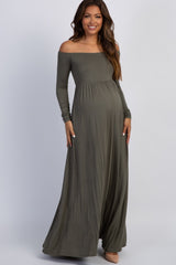 woman wearing a long sleeve olive green maternity dress and holding her baby bump