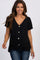 woman wearing a black short sleeve button down top with a front tie knot and blue jeans