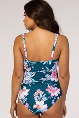 woman wearing a floral green maternity swimsuit, showcasing a fitted design and adjustable straps from the back