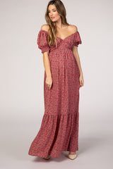 woman wearing a floral off-the-shoulder maternity maxi dress with puff sleeves and a tiered hemline