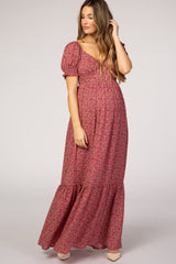 woman wearing a floral print maternity maxi dress with puff sleeves and a tiered hem, highlighting her baby bump
