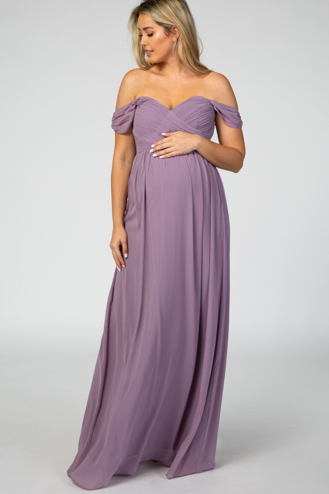woman wearing a lavender off-the-shoulder maternity gown and holding her baby bump