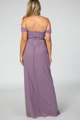 woman wearing a lavender off-the-shoulder maternity maxi dress, showing the back view and a fitted smocked bodice