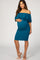 woman wearing a teal off-the-shoulder maternity dress with ruffle details and showing her baby bump