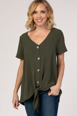 woman wearing an olive green short sleeve button down top with a front tie hem and blue jeans