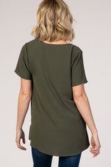 woman wearing a dark green short sleeve top with a curved hem and relaxed fit, viewed from the back