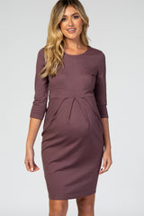 woman wearing a mauve 3/4 sleeve maternity dress with a pleated front and baby bump visible