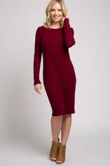 woman wearing a burgundy long sleeve fitted dress and tan heeled ankle boots