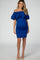 woman wearing a royal blue off-shoulder maternity dress with ruffle detailing and visible baby bump