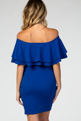 woman wearing a royal blue off-the-shoulder maternity dress with layered ruffle details on the sleeves