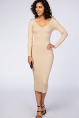 woman wearing a beige ribbed fitted midi dress with long sleeves and a deep v-neckline