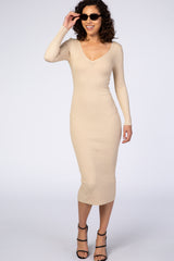 woman wearing a beige ribbed knit midi dress with long sleeves and a v-neckline, accessorized with sunglasses