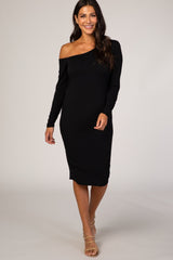 woman wearing a fitted black long sleeve off-shoulder dress with a midi length