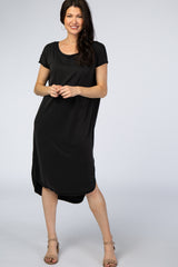 woman wearing a black short sleeve midi t-shirt dress with tan block heel sandals