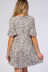 woman wearing a spotted maternity dress with ruffle sleeves and a tiered skirt, showing the back view